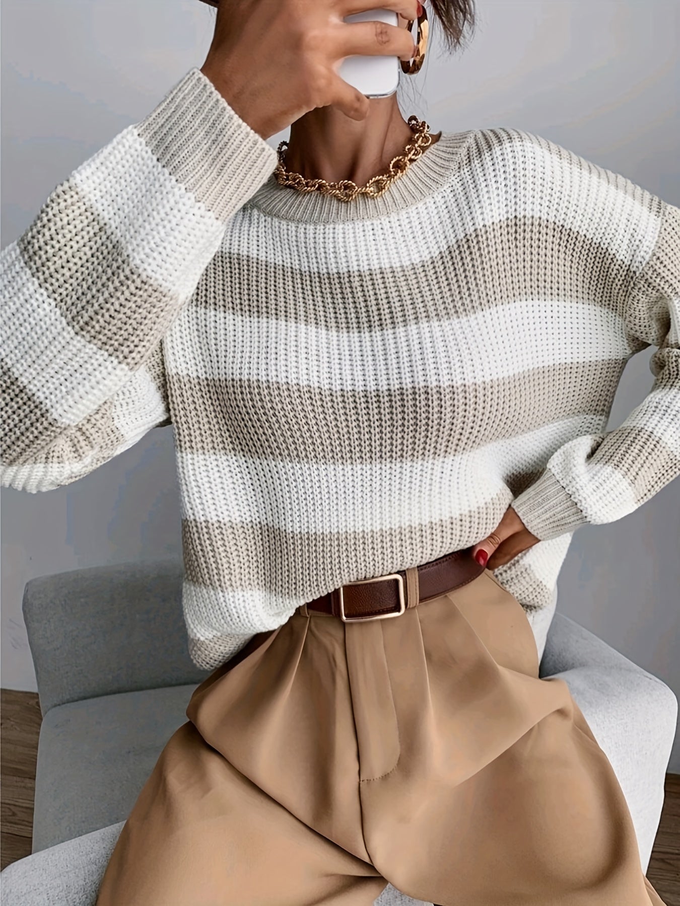 Model wears striped knitted jumper for winter.