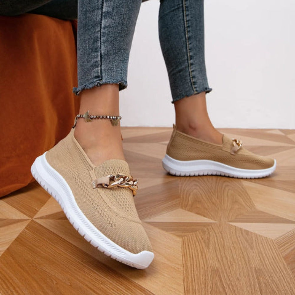 styled and breathable shoes with a gold button on top.